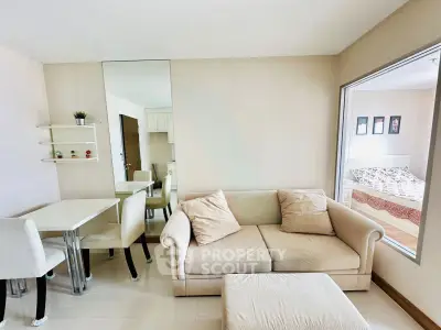 Modern living room with cozy sofa and dining area, adjacent to a bright bedroom.