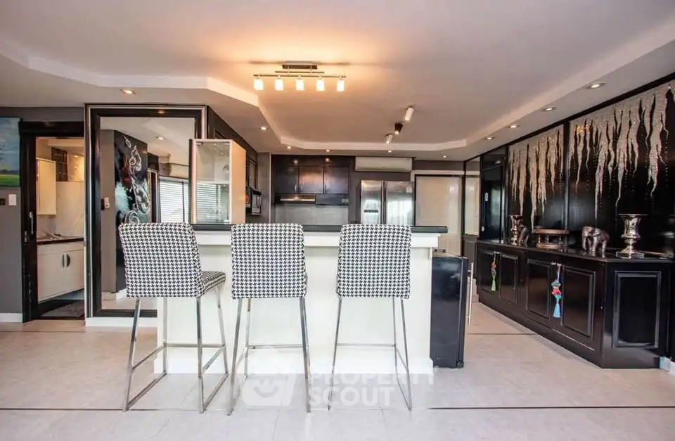 Modern kitchen with stylish bar stools and sleek black cabinetry