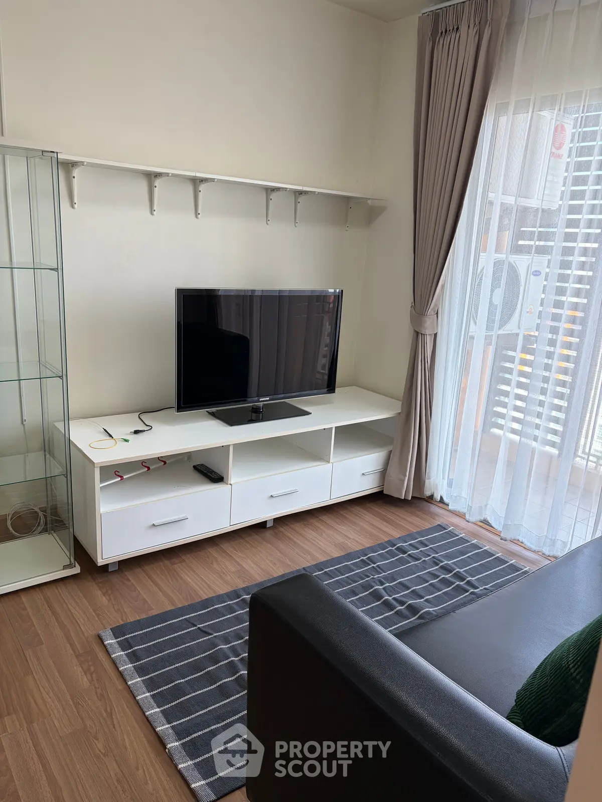 Modern living room with sleek TV stand and cozy sofa, perfect for relaxation.