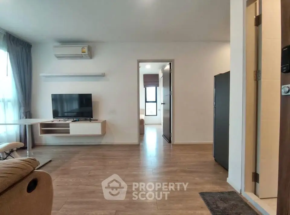 Modern living room with wooden flooring and sleek TV setup