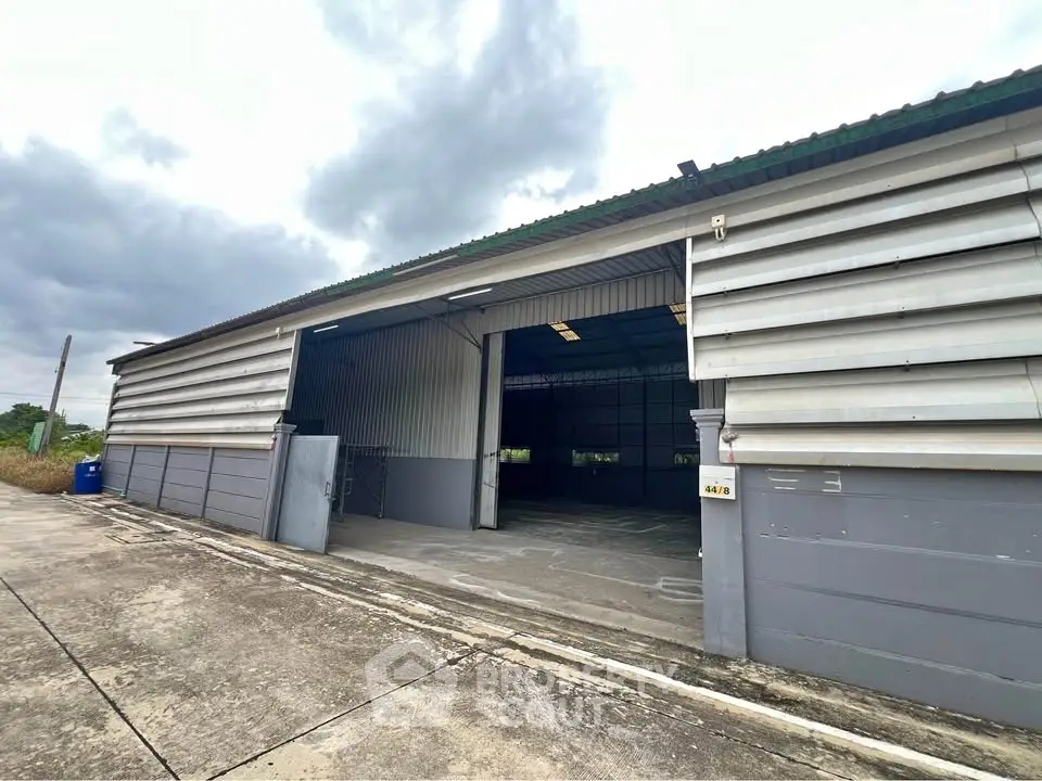 Spacious industrial warehouse with open entrance and ample outdoor space.