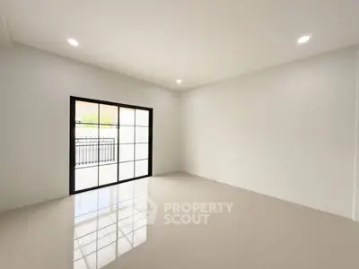 Spacious empty room with large window and glossy tiled floor