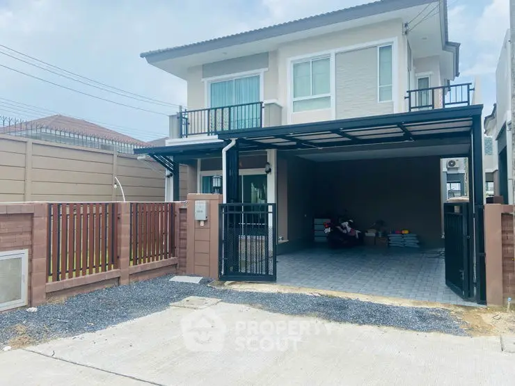 Modern two-story house with gated driveway and spacious garage in suburban setting.
