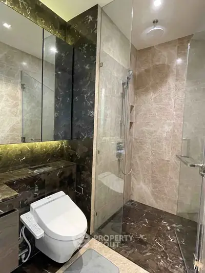 Luxurious modern bathroom with marble finishes and high-tech toilet in upscale property.