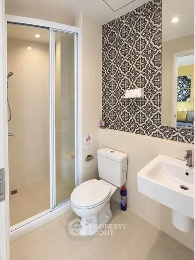 Modern bathroom with stylish tile accent wall and glass shower enclosure