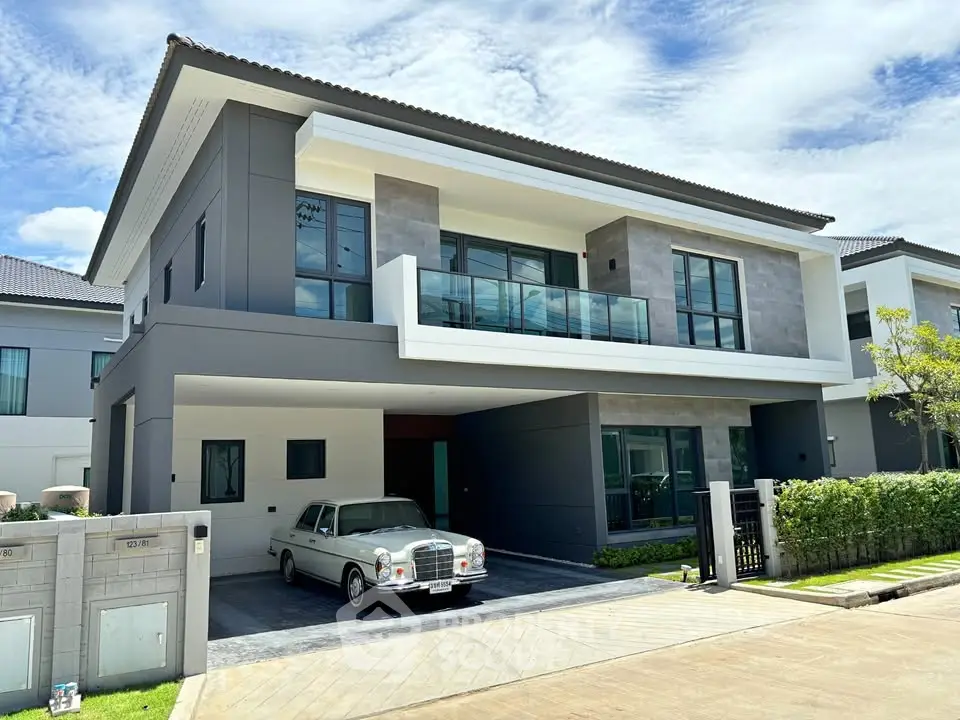 Modern two-story house with sleek design and classic car parked in driveway.