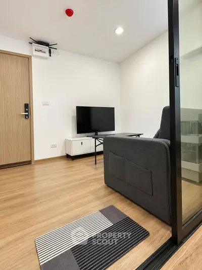 Modern living room with sleek furniture and wooden flooring in a contemporary apartment.