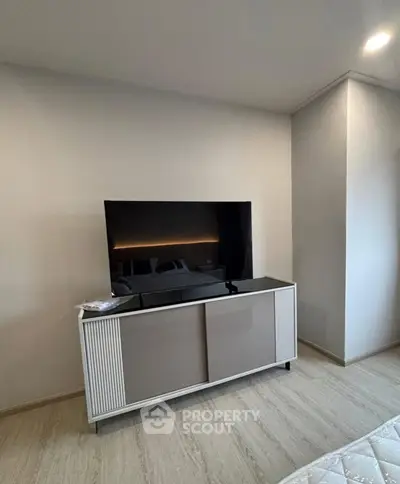 Modern living room with sleek TV stand and large flat-screen TV, perfect for entertainment.