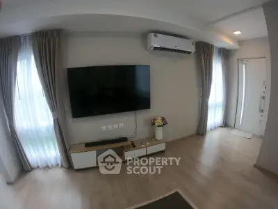 Modern living room with wall-mounted TV and air conditioning, featuring elegant curtains and wooden flooring.