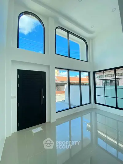 Spacious modern living room with high ceilings and large windows for natural light.
