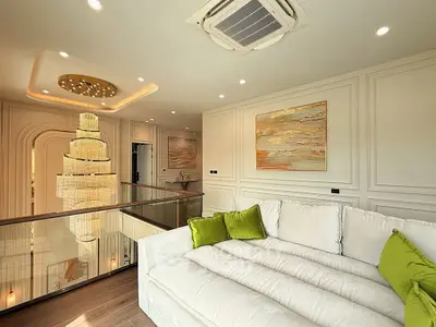 Luxurious living room with elegant chandelier and plush white sofa, perfect for sophisticated living.