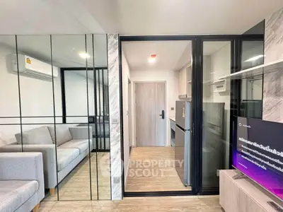 Modern apartment interior with mirrored wall, cozy living room, and sleek kitchen design.