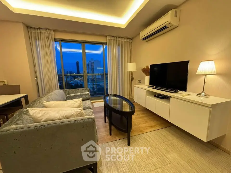 Modern living room with city view, featuring sleek furniture and ambient lighting.