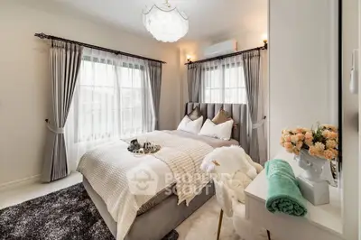 Elegant bedroom with plush bedding and natural light, perfect for relaxation.