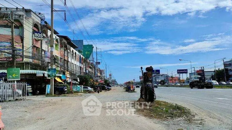 Street view of commercial buildings with clear blue sky and road access, ideal for business opportunities.
