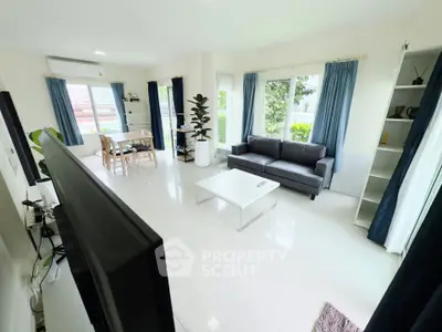 Spacious living room with modern decor and large windows for natural light.