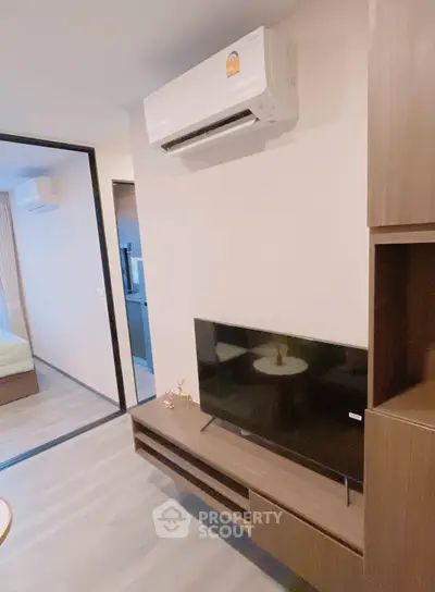 Modern living room with sleek TV unit and air conditioning in a stylish apartment.