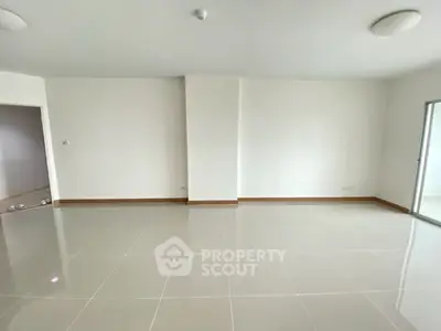 Spacious empty living room with glossy tiled floors and white walls