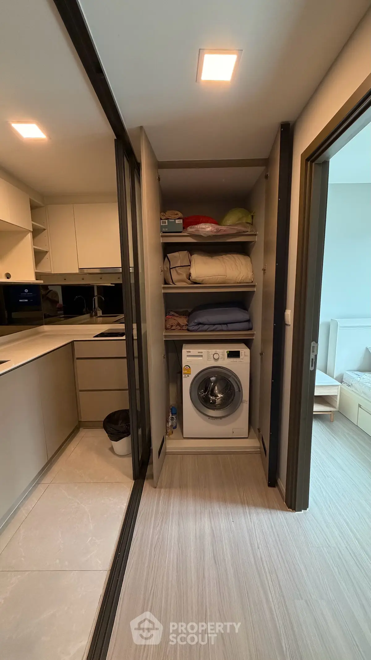 Modern apartment with sleek kitchen and hidden laundry area, featuring built-in appliances and ample storage.