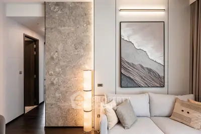 Modern living room with elegant decor and stylish lighting, featuring a cozy sofa and artistic wall art.