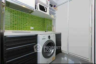 Modern kitchen with washing machine and vibrant green backsplash