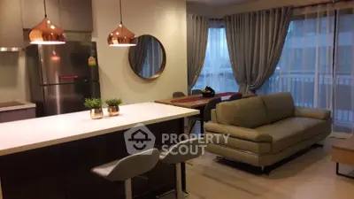 Modern open-layout kitchen and living room with stylish decor and large windows.