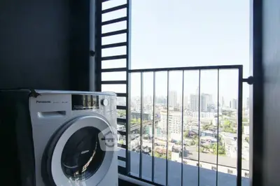 Modern apartment balcony with city view and washing machine