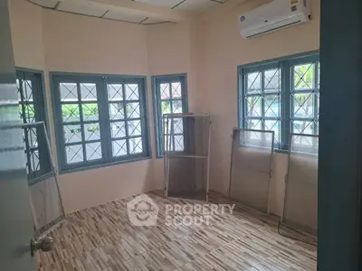 Bright room with large windows and air conditioning, perfect for a cozy study or office space.