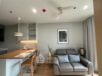 Modern open-plan living room with cozy seating and stylish kitchen area