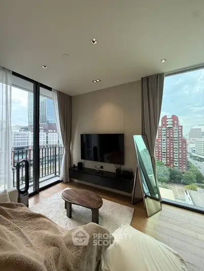 Spacious living room with large windows offering stunning city views and modern decor.