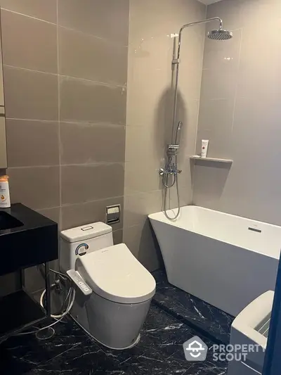 Modern bathroom with sleek fixtures, including a high-tech toilet, rainfall showerhead, and a freestanding bathtub on elegant dark marble flooring.