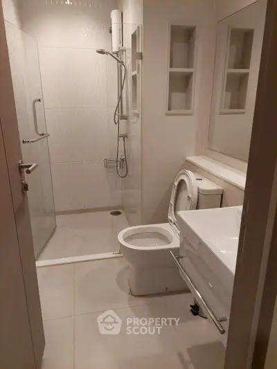 Modern bathroom with sleek shower and contemporary fixtures in a stylish apartment.