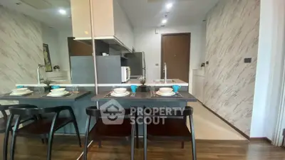 Modern kitchen with sleek design and dining area, featuring stylish chairs and elegant tableware.