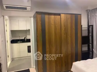 Modern apartment interior with sleek kitchen and stylish wooden wardrobe