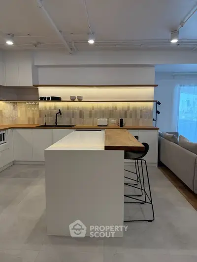 Modern kitchen with sleek design, featuring an open layout and stylish bar seating, perfect for contemporary living.