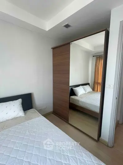 Cozy bedroom with mirrored wardrobe and twin beds, perfect for a comfortable stay.