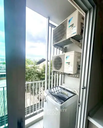 Compact balcony with washing machine and air conditioning units, ideal for urban living.