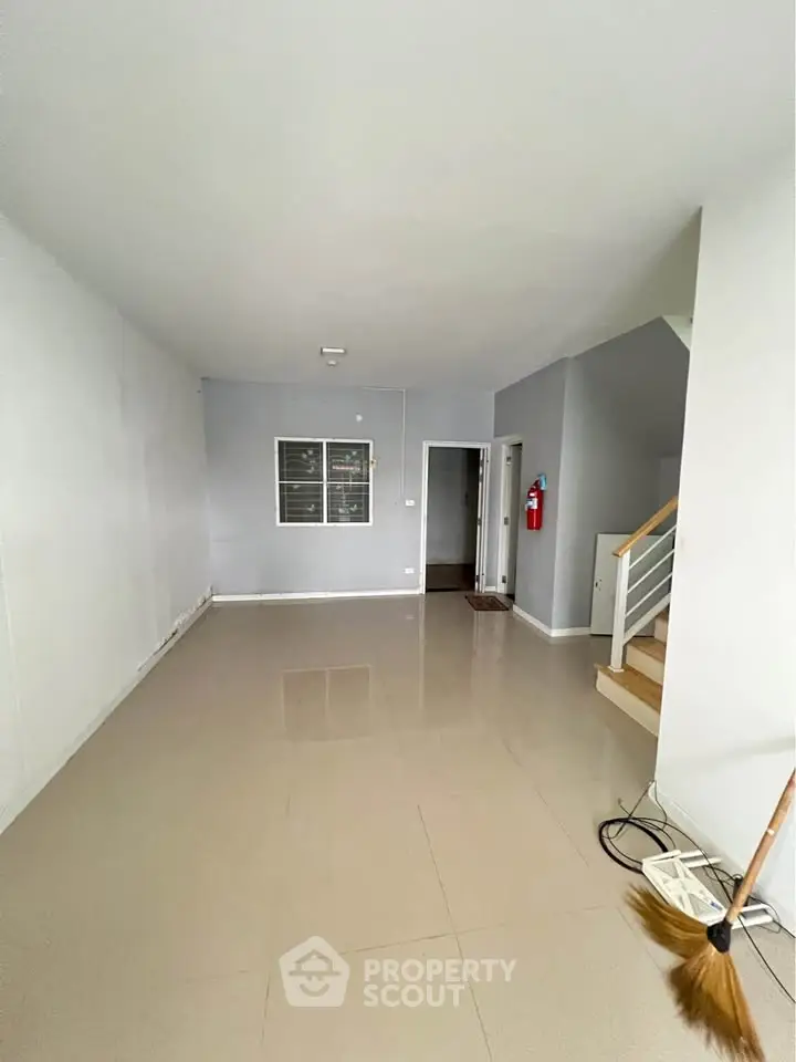 Spacious empty room with staircase, ideal for customization and modern living.