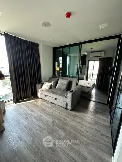Modern apartment with stylish living room and bedroom, featuring floor-to-ceiling windows and sleek decor.