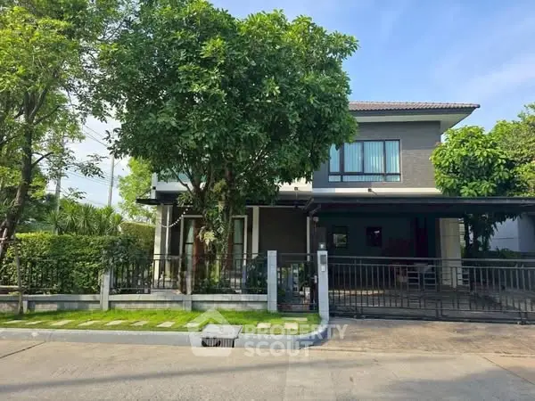 Charming two-story house with lush greenery and modern design in a serene neighborhood.