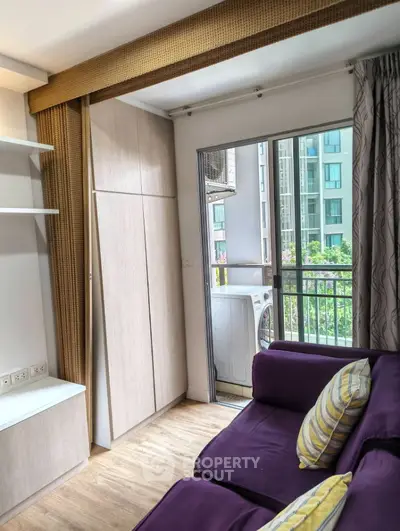 Cozy living room with purple sofa and balcony view in modern apartment