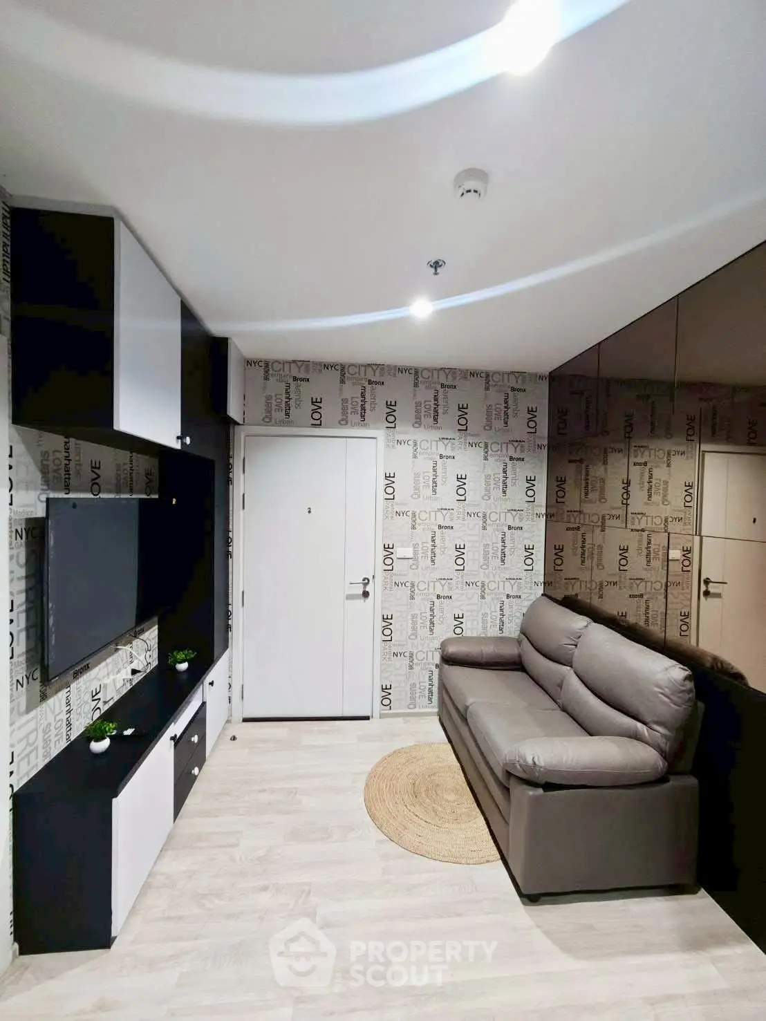 Modern living room with stylish wallpaper and sleek furniture in a cozy apartment.