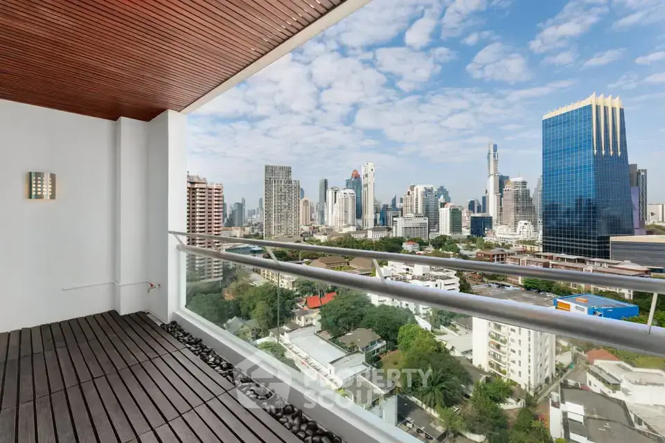 Stunning cityscape view from a modern balcony with wooden flooring and sleek railing.