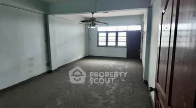 Spacious empty room with ceiling fan and large windows