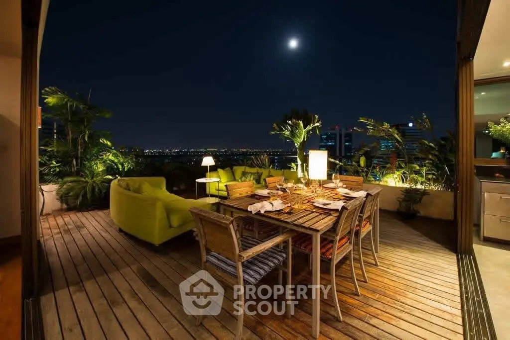 Luxurious rooftop terrace with elegant dining setup and stunning night city view.