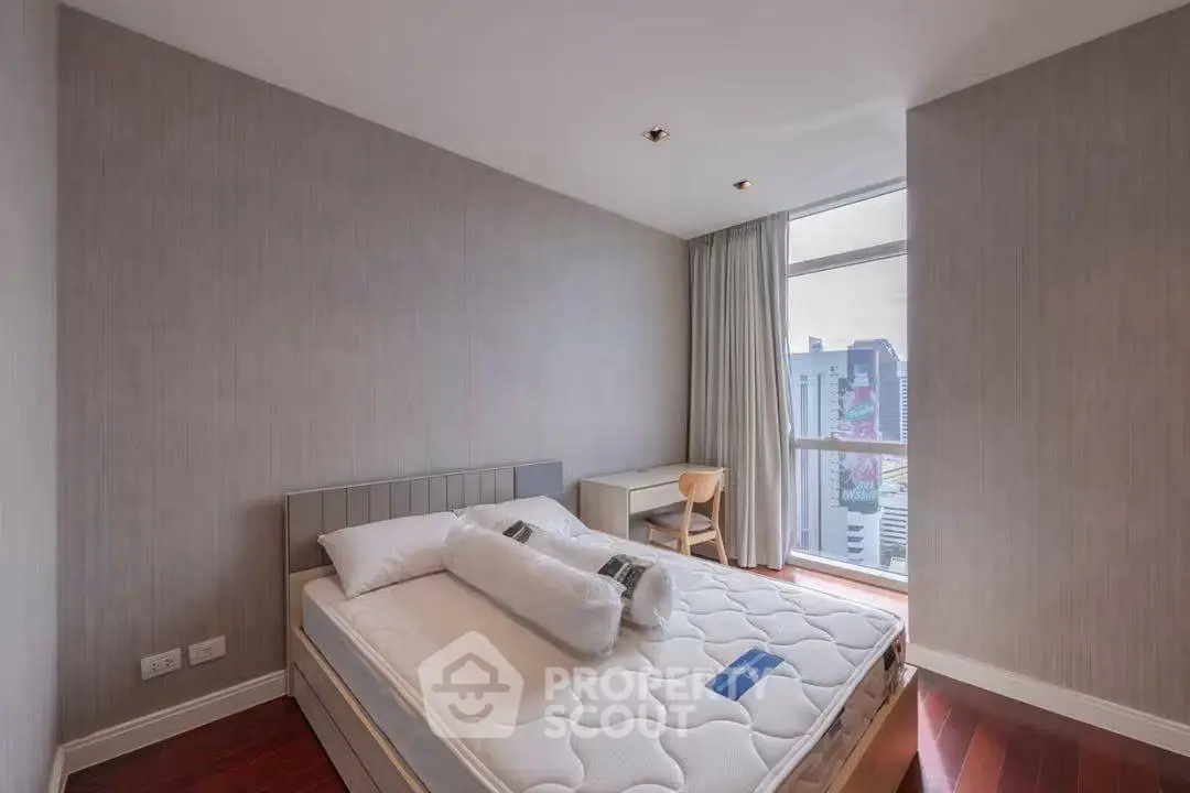 Modern bedroom with city view, featuring a cozy bed and stylish decor, perfect for urban living.