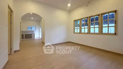 Spacious living room with wooden flooring and large windows in modern home