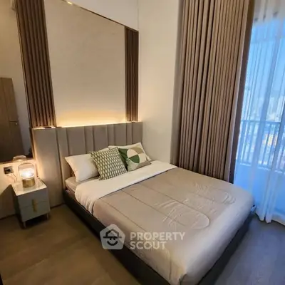 Modern bedroom with elegant decor and large window offering natural light