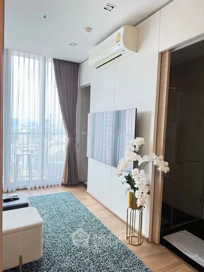 Modern living room with large window and city view, featuring elegant decor and air conditioning.
