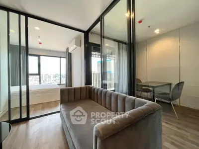 Modern apartment with glass partitions, cozy living area, and city view.